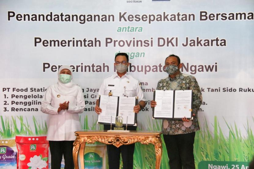 Gubernur DKI Jakarta Anies Baswedan (tengah) dan Bupati Ngawi, Ony Anwar, menandatangani perjanjian kerja sama hasil pertanian di Kecamatan Geneng, Ngwai, Ahad (25/4). Gubernur Provinsi Jawa Timur, Khofifah Indar Parawansa (kiri) turut menyaksikan penandatanganan itu. 
