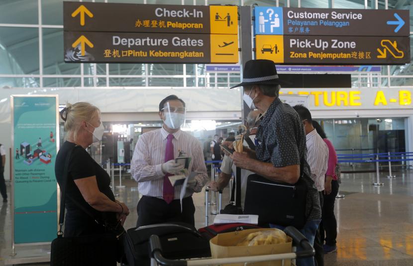 Warga Australia diperiksa oleh petugas keamanan saat keberangkatannya di Bandara Internasional Ngurah Rai, Bali, Indonesia pada Rabu, 18 Agustus 2021. 