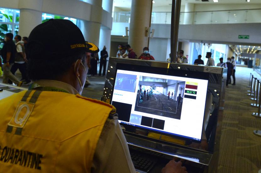 Petugas memantau suhu tubuh menggunakan alat pemindai suhu tubuh saat simulasi penerbangan internasional di Bandara Internasional I Gusti Ngurah Rai, Badung, Bali, Sabtu (9/10/2021). Simulasi tersebut dilakukan untuk memastikan kesiapan petugas dan sarana prasarana serta menguji standar operasional prosedur dalam pelayanan penumpang penerbangan internasional di Bandara Ngurah Rai yang rencananya akan mulai dibuka pada 14 Oktober 2021 mendatang.