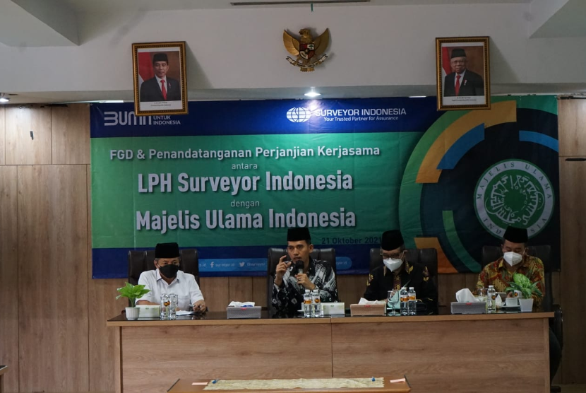 Direktur Utama PT Surveyor Indonesia M Haris Witjaksono (kiri) dan Ketua MUI Bidang Fatwa Asrorun Niam Sholeh (kedua dari kiri) dalam penandatanganan MoU tentang penetapan kehalalan produk oleh MUI dalam proses sertifikasi produk halal di Jakarta, Kamis (21/10).   