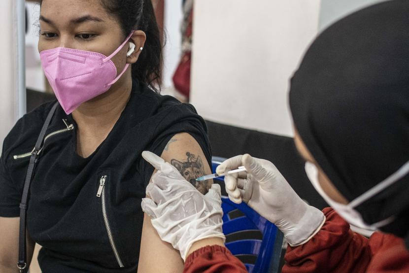 Vaksinator menyuntikkan vaksin Covid-19 kepada warga di Gelanggang Remaja Kecamatan Matraman, Jakarta, Selasa (16/11/2021).