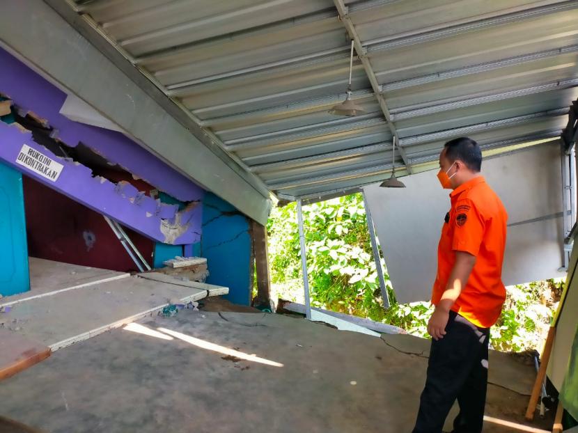 Petugas memantau kondisi rumah yang tergerus aliran sungai di Kelurahan Ciherang, Kecamatan Cibeureum, Kota Tasikmalaya, Kamis (18/11). 