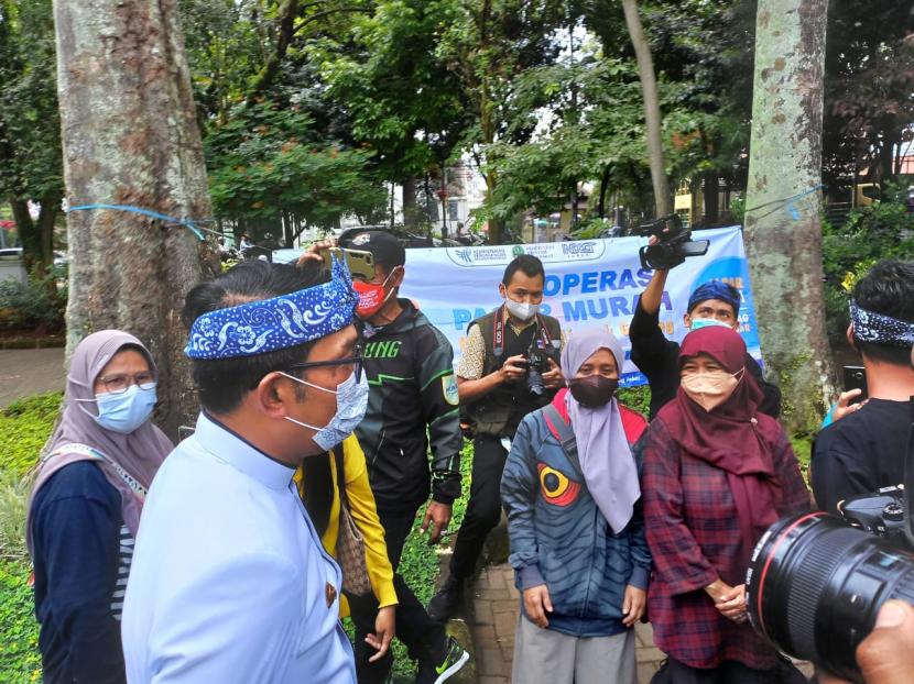 Gubernur Jawa Barat Ridwan Kamil meninjau operasi pasar murah di Taman Dewi Sartika, Kota Bandung, Kamis (13/1). Sebanyak 7.200 botol minyak goreng ukuran satu liter dijual dengan harga Rp 14 ribu. 