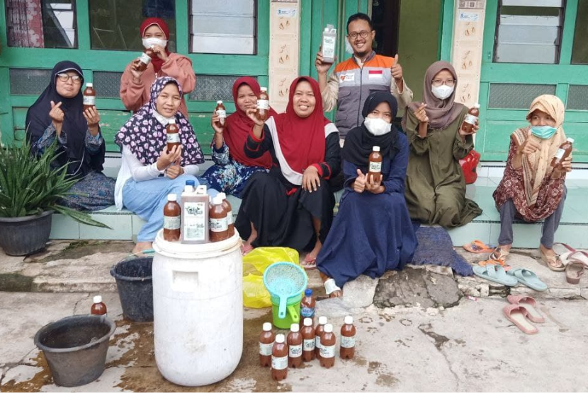 Relawan Rumah Zakat, Bagus Pandu, mengajak para ibu-ibu anggota Rumah Quran untuk membuka drum eco enzim.