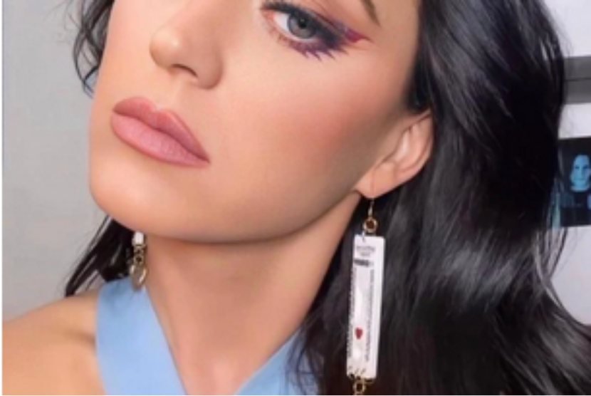 Katy Perry mengenakan anting yang terbuat dari kit tes antigen bekas.