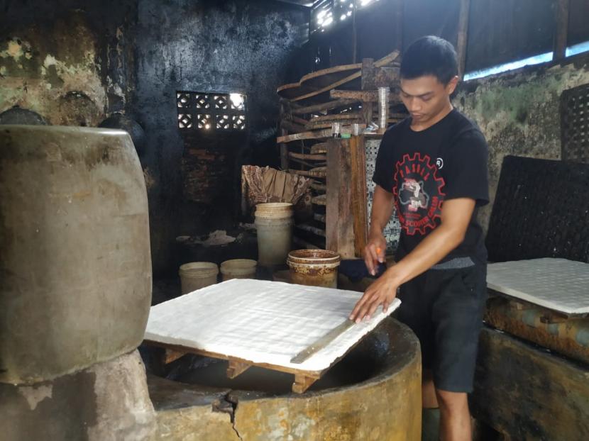 Salah seorang perajin tahu di Kampung Tahu, Dusun Cibodas, Desa Cisadap, Kecamatan Ciamis, Kabupaten Ciamis, memproduksi tahu untuk pesanan, Senin (21/2/2022). Para perajin tahu di kampung itu mogok produksi untuk dikirim ke pasar.
