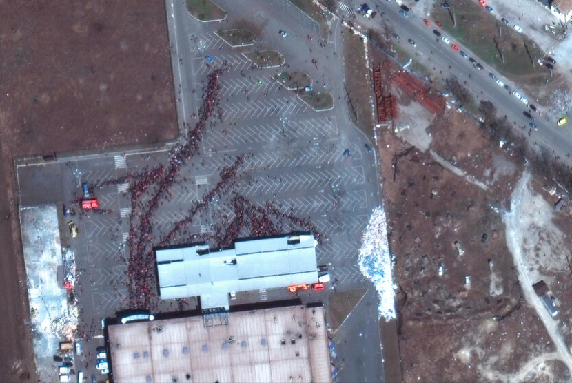 Citra satelit yang disediakan oleh Maxar Technologies ini menunjukkan kerumunan orang di luar toko kelontong di Mariupol, Ukraina, Selasa (29/3/2022). Sebuah gudang makanan di kota Brovary, utara Ukraina yang hancur dalam serangan Rusia. 
