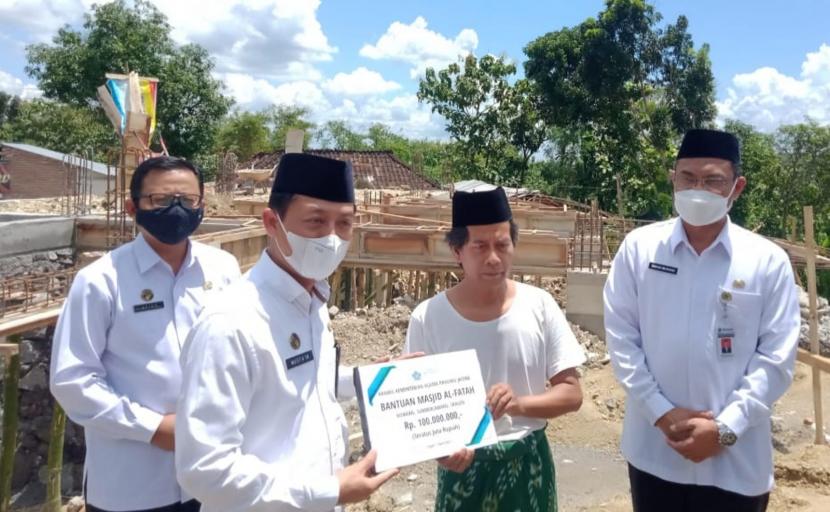 Kepala Kantor Wilayah Kemenag Jawa Tengah, H Musta’in Ahmad, saat menyerahkan bantuan uang Rp 100 juta guna membantu pembangunan kembali Masjid Al Fatah, Dusun Kowang, Desa Ngargotirto, Kecamatan Sumberlawang, Kabupaten Sragen, Jawa Tengah, kemarin.