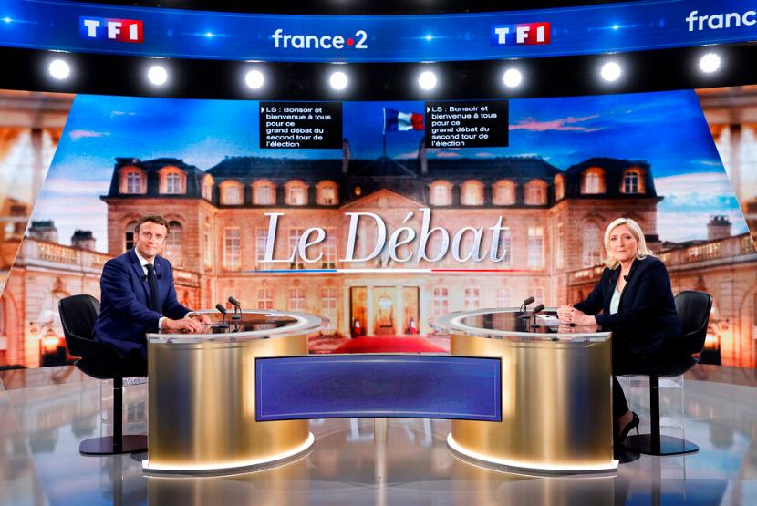 Kandidat sentris dan Presiden Prancis Emmanuel Macron, kiri, dan pesaing sayap kanan Marine Le Pen berpose di depan debat televisi di La Plaine-Saint-Denis, di luar Paris, Rabu, 20 April 2022. Macron Sebut Larangan Jilbab Le Pen Ciptakan Perang Saudara di Prancis
