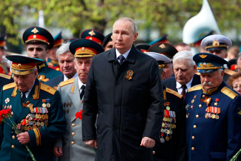 Presiden Rusia Vladimir Putin, tengah, menghadiri upacara peletakan karangan bunga di Makam Prajurit Tak Dikenal setelah parade militer menandai peringatan 77 tahun berakhirnya Perang Dunia II, di Moskow, Rusia, Senin, 9 Mei 2022.