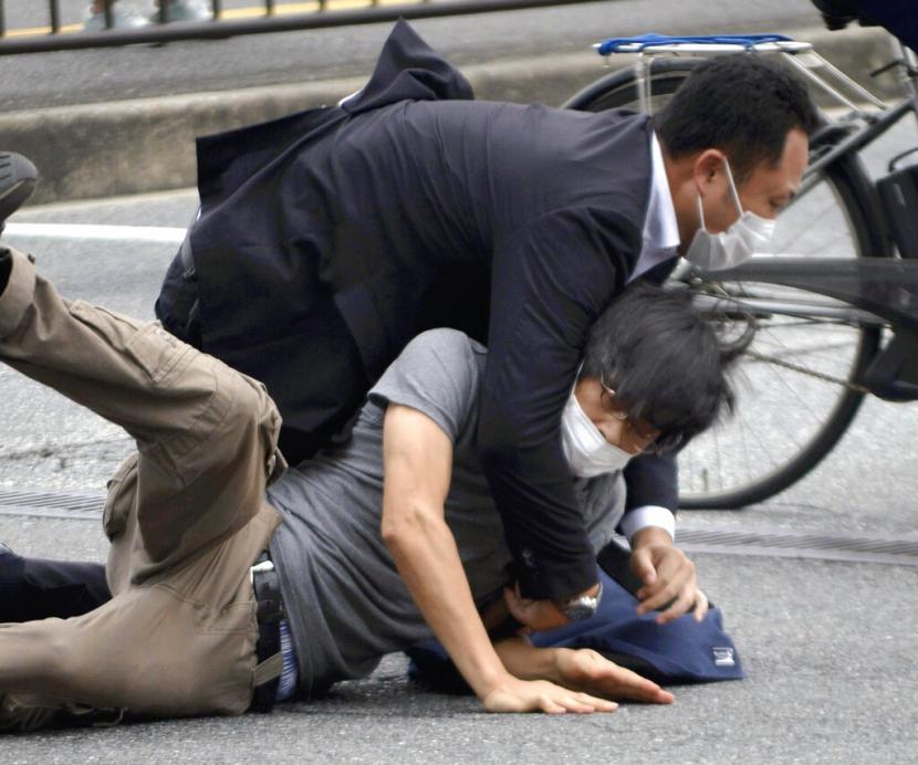 Petugas mengamankan Tetsuya Yamagami (bawah), pelaku yang menembak mantan Perdana Menteri Jepang Shinzo Abe  di sekat Stasiun Yamatosaidaiji, Nara, Jumat (8/7/2022).