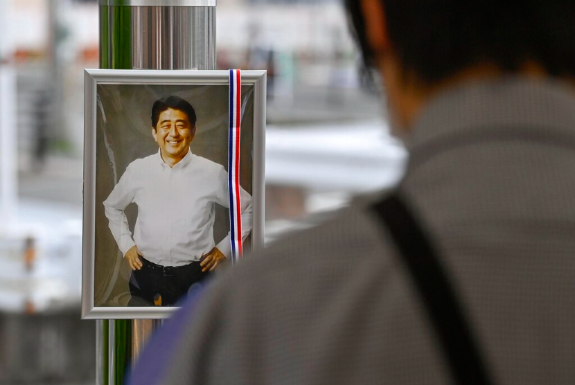 Foto mantan Perdana Menteri Jepang Shinzo Abe dipajang di area peringatan dekat lokasi di mana Abe ditembak mati di Nara, Jepang barat Jumat, 15 Juli 2022. Banyak orang berduka atas kematian Abe di lokasi di mana dia ditembak mati. selama pidato kampanye seminggu yang lalu Jumat, mengejutkan sebuah negara yang dikenal dengan tingkat kejahatan yang rendah dan kontrol senjata yang ketat.