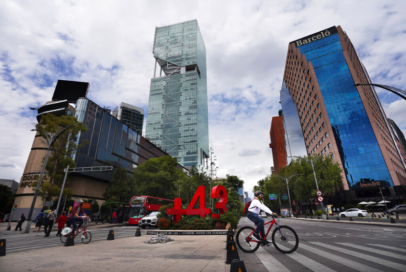 Seorang pengendara sepeda mengayuh melewati sebuah monumen yang didedikasikan untuk penghilangan 43 siswa tahun 2014 dari sebuah perguruan tinggi guru radikal negara bagian Guerrero, di Mexico City, Sabtu, 20 Agustus 2022. Seorang jurnalis Meksiko kembali ditembak mati. Ia merupakan jurnalis keempat yang dibunuh bulan ini.