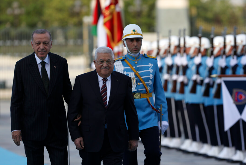 Presiden Turki Recep Tayyip Erdogan, kiri, dan Presiden Palestina Mahmoud Abbas meninjau pengawal kehormatan militer selama upacara penyambutan di Ankara, Turki, Selasa, 23 Agustus 2022. Abbas berada di Turki untuk kunjungan kenegaraan dua hari.