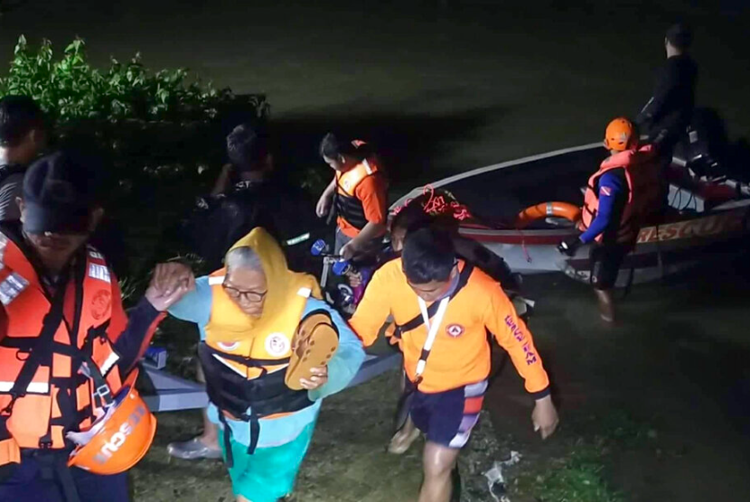 Dalam foto yang disediakan oleh Penjaga Pantai Filipina ini, penyelamat membantu penduduk saat mereka memindahkan mereka ke tempat yang lebih aman saat banjir yang disebabkan oleh Badai Tropis Ma-on naik di Alaminos, Pangasinan, Filipina utara pada Selasa, 23 Agustus 2022. Badai tropis bertiup keluar dari Filipina utara pada hari Rabu, meninggalkan setidaknya beberapa orang terluka dan ribuan mengungsi dan mendorong pihak berwenang untuk menutup sekolah dan kantor-kantor pemerintah di ibukota dan beberapa provinsi rawan banjir dan tanah longsor