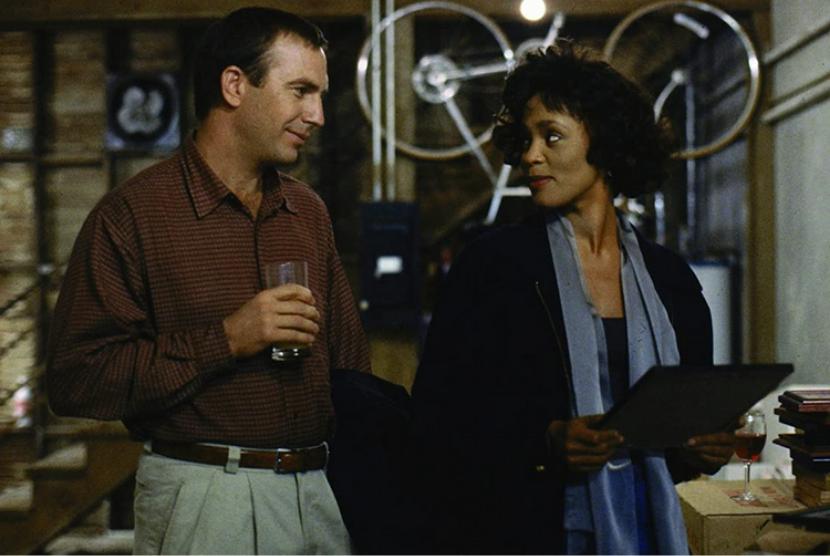 Aktor Kevin Costner (kiri) beradu akting dengan penyanyi Whitney Houston dalam film The Bodyguard (1992).