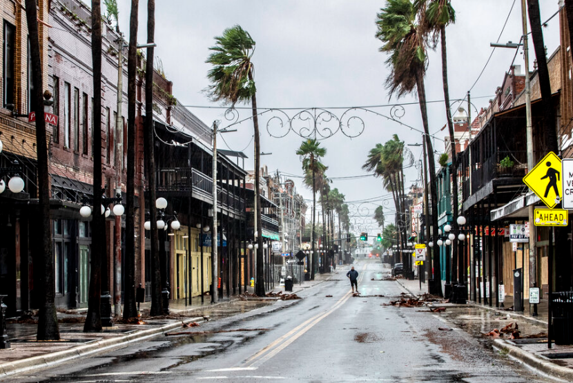 Seorang pria berdiri di tengah 7th Street di Ybor City di jalanan yang diguyur hujan, beberapa jam sebelum angin kencang dari Badai Ian menghantam Tampa, Florida, Rabu, 28 September 2022.