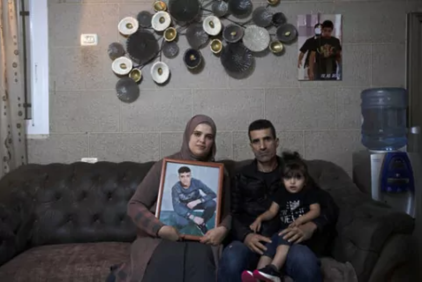 Maysoon, kiri, dan Saleh Manasra, orang tua Ahmad Manasra, yang telah dipenjara oleh Israel sejak dia berusia 13 tahun ketika dia dihukum karena percobaan pembunuhan dan dijatuhi hukuman sembilan setengah tahun penjara, setelah kakak sepupunya menikam dua orang Israel, berfoto bersama putri mereka, Sham, di rumahnya di Yerusalem timur, Selasa, 8 November 2022. Bocah Palestina berusia 13 tahun yang kasusnya menjadi penyulut konflik Israel-Palestina tujuh tahun lalu itu sekarang seorang pria mendekam di sel isolasi dan berjuang melawan skizofrenia. Minggu ini, Mahkamah Agung Israel akan memutuskan banding untuk pembebasannya lebih awal.