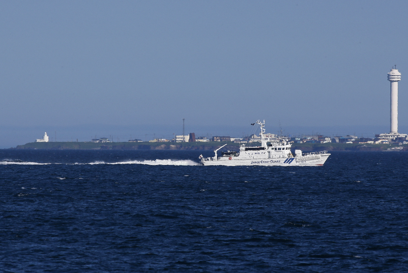 Sebuah foto yang tersedia pada 16 Juli 2013 dari kapal Penjaga Pantai Jepang Kawagiri yang berpatroli di Tanjung Nosappu (belakang), dekat pulau Kuril paling selatan Pulau Kunashir, di bawah pemerintahan Rusia dan diklaim oleh Jepang, dekat Nemuro, di pulau Hokkaido, Jepang, 13 Juli 2013 .