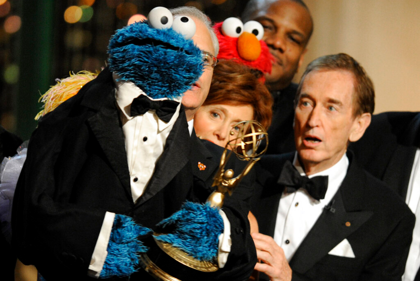 Aktor Bob McGrath (kanan) didampingi Cookie Monster saat menerima Lifetime Achievement Award dalam perannya di Sesame Street dalam gelaran Daytime Emmy Awards pada 30 Agustus 2009 di AS. McGrath meninggal dalam usia 90 tahun, menurut keterangan keluarga melalui Facebook pada Ahad (4/12/2022).