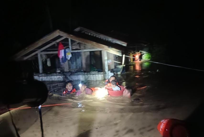 Foto selebaran yang disediakan oleh Penjaga Pantai Filipina (PCG) menunjukkan personel penjaga pantai mengevakuasi penduduk dari rumah yang terendam banjir pada hari Natal di kota Ozamiz, provinsi Misamis Occidental, Filipina, 25 Desember 2022 (diterbitkan pada 26 Desember 2022).