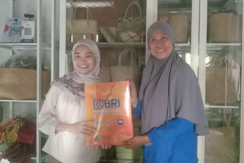 Eva Harlia bersama para perempuan kelompk usaha Menday Gallery and Souvenir yang mengolah daun pandang menjadi beragam souvenir di pesisir Sumatera Utara.