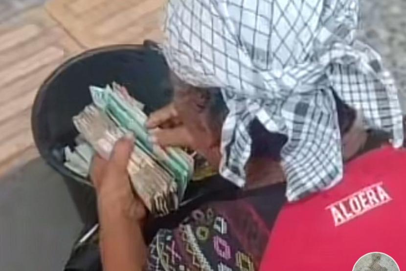 Tangkapan layar dari video di jejaring sosial yang memperlihatkan pengemis sedang menghitung uang yang tebal.