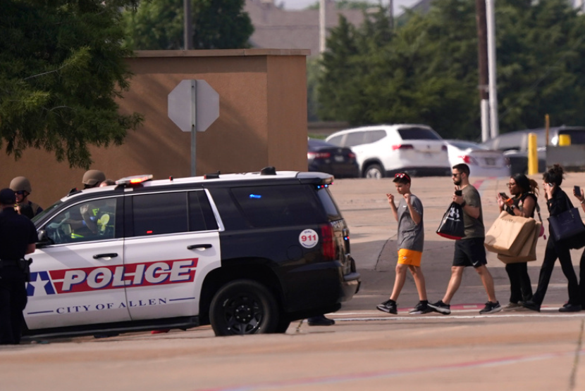 Orang-orang mengangkat tangan saat meninggalkan pusat perbelanjaan menyusul laporan penembakan, Sabtu, 6 Mei 2023, di Allen, Texas.