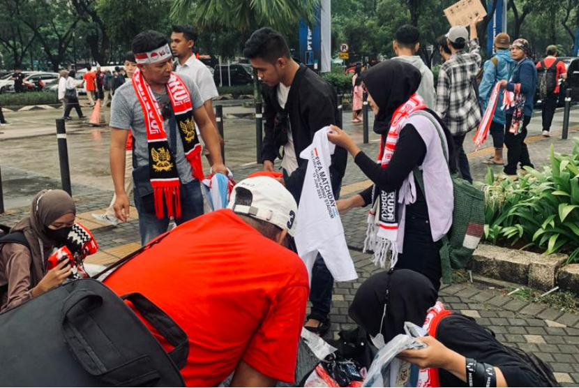 Wahyu (kiri berdiri) menjual jersey dan pernak pernik timnas Indonesia dan Argentina jelang laga Indonesia vs Argentina di Stadion Utama Gelora Bung Karno, Senayan, Jakarta, Senin (19/6/2023)
