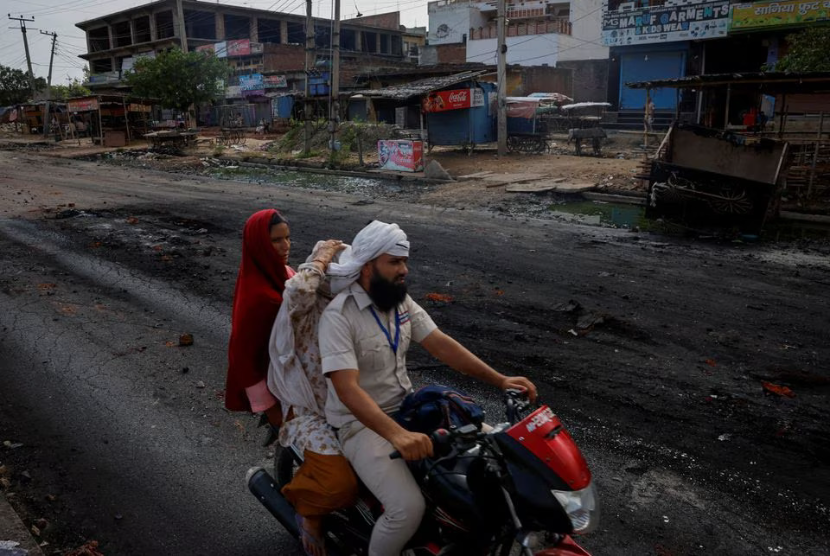 Sebuah keluarga mengendarai sepeda motor di jalan sepi menyusul bentrokan antara umat Hindu dan Muslim di Distrik Nuh, Haryana, India, 1 Agustus 2023. 