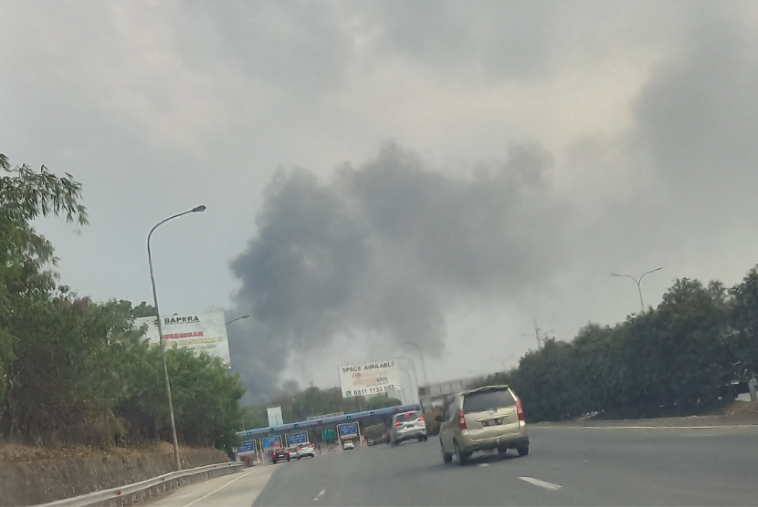 Asap membubung terlihat dari pintu tol Cibubur, Jakarta Timur, Sabtu (14/10/2023). Gudang kabel di wilayah Cimanggis, Kota Depok, Jawa Barat, terbakar.