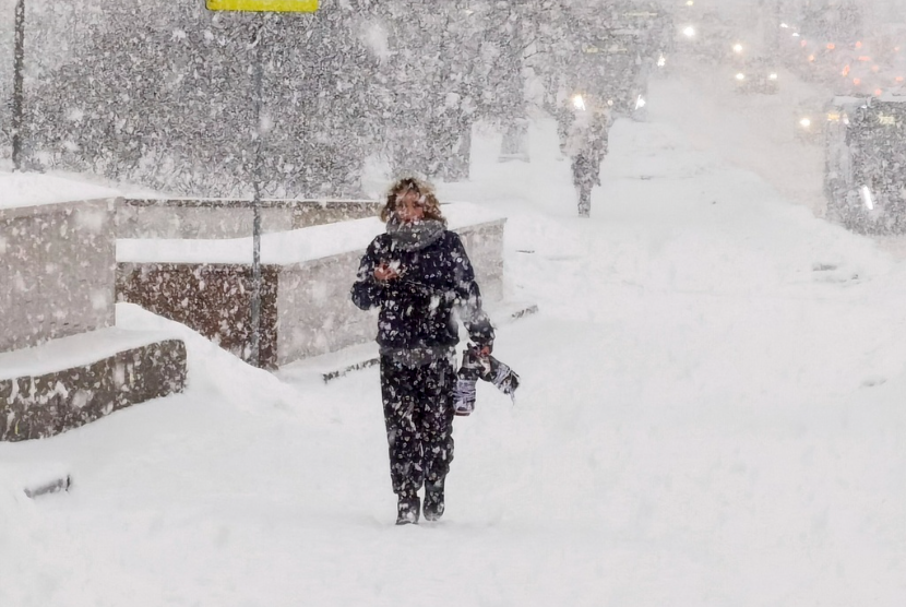 Seorang pria berjalan di jalan saat hujan salju lebat di Moskow, Rusia, Senin, 4 Desember 2023. Rekor hujan salju melanda ibu kota Rusia menambah 10 cm (3,9 inci) salju yang sudah tinggi dan menyebabkan gangguan pada bandara ibu kota dan jalan raya.