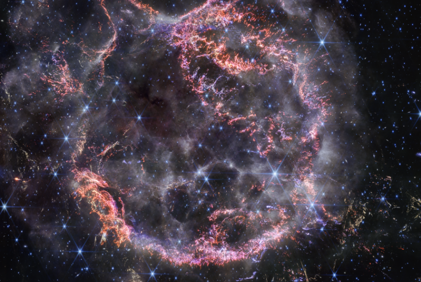 Pandangan baru Teleskop Luar Angkasa James Webb milik NASA terhadap Cassiopeia A (Cas A) dalam cahaya inframerah-dekat memberikan petunjuk kepada para astronom tentang proses dinamis yang terjadi dalam sisa-sisa supernova. Gumpalan kecil berwarna merah muda cerah dan oranye membentuk cangkang dalam supernova, dan terdiri dari belerang, oksigen, argon, dan neon dari bintang itu sendiri.