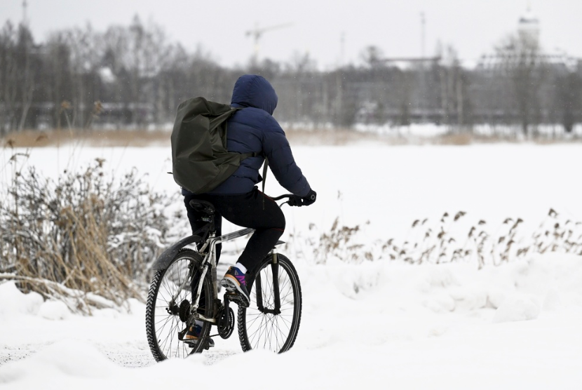 Seorang warga mengendarai sepeda di jalan bersalju di Helsinki, Finlandia, Jumat (5/1/2024). Suhu terdingin abad ini di Finlandia terpantau terjadi pada Jumat di Enonteki, selatan kota Lapland, yakni -44,3 derajat Celsius.
