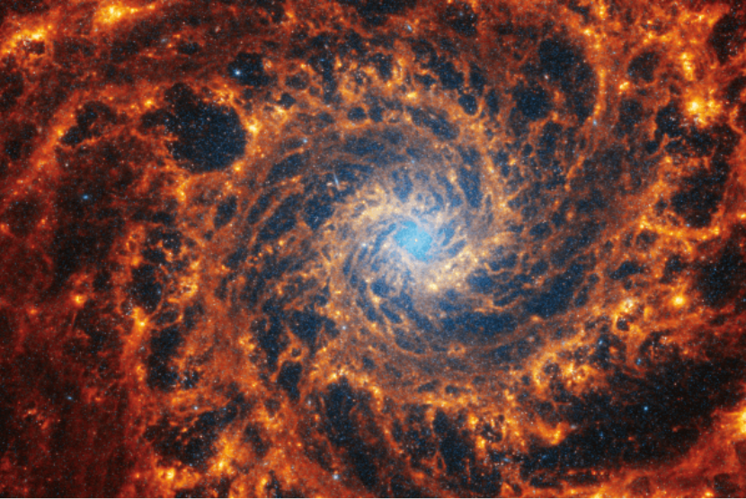 Galaksi spiral NGC 628 berjarak 32 juta tahun cahaya di konstelasi Pisces. Gambar NGC 628 yang diambil oleh Webb menunjukkan galaksi spiral berpenduduk padat yang terletak di wilayah tengahnya, yang memiliki kabut biru muda yang menempati sekitar seperempat pandangan.