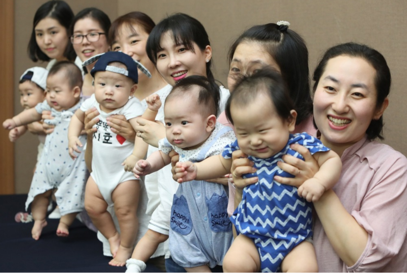 Ibu-ibu di Seoul, Korea Selatan menggendong bayinya pada 27 Juni 2019. Seoul menghadapi rendahnya angka kelahiran, sementara angka bunuh dirinya tinggi.