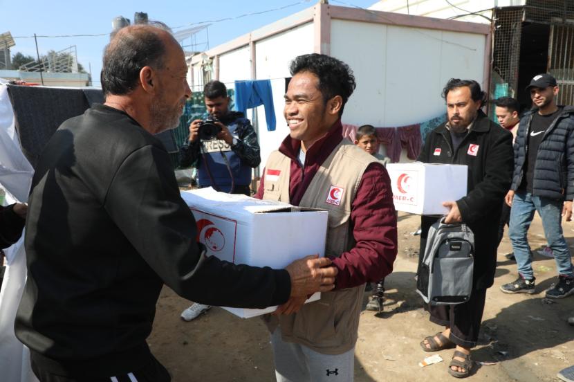 Salah satu relawan MER-C Gaza menyerahkan paket bantuan makanan untuk pengungsi Gaza. 