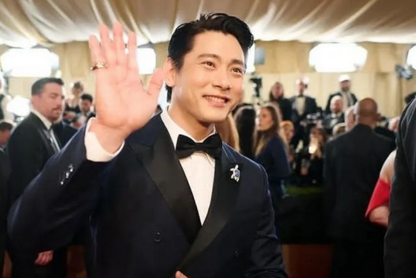 Aktor Korea Teo Yoo memakai pin kura-kura di kerah jasnya saat hadiri Oscar.