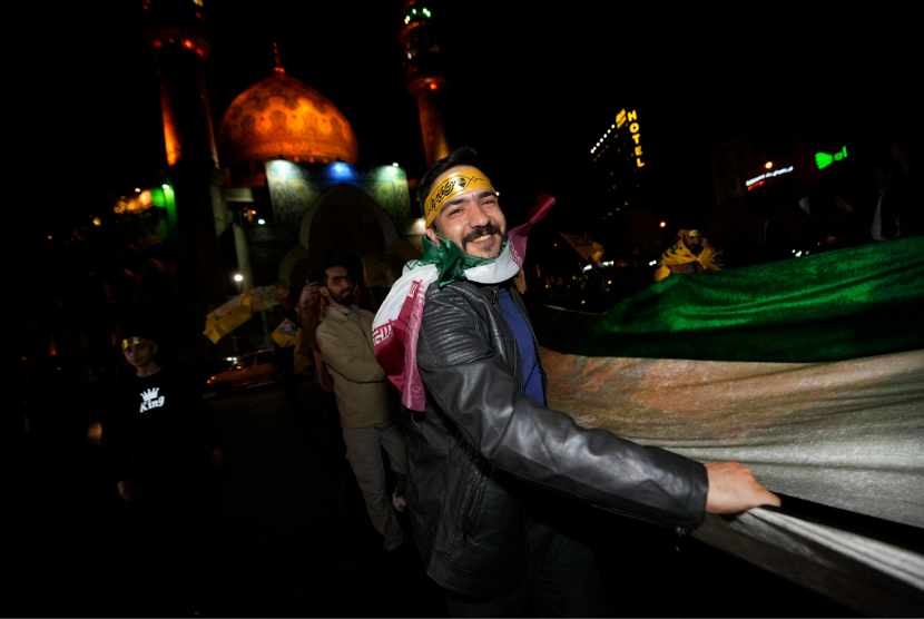 Demonstran Iran merayakan kabar serangan ke Israel dalam aksi di Lapangan Felestin (Palestina) di Teheran, Ahad dini hari, 14 April 2024.