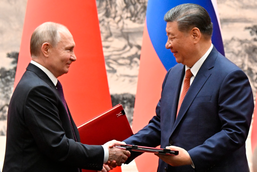 Presiden China Xi Jinping, kanan, dan Presiden Rusia Vladimir Putin bertukar dokumen usai upacara penandatanganan dalam pertemuan mereka di Beijing, Tiongkok, pada Kamis, 16 Mei 2024. 