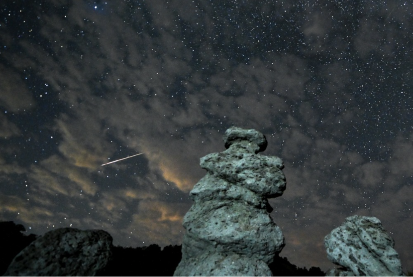 Foto eksposur panjang menunjukkan guratan meteor melintasi langit malam di atas boneka batu di Kuklica, Republik Makedonia Utara, 13 Agustus 2023. Hujan meteor Perseid terjadi setiap tahun di bulan Agustus saat Bumi melewati puing-puing dan debu komet Swift-Tuttle.