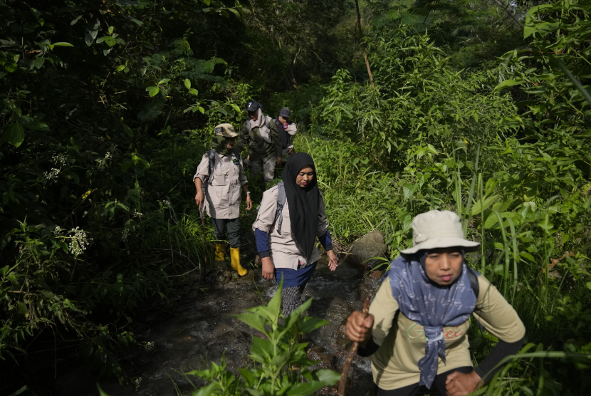 Para jagawana perempuan berjalan di sepanjang sungai saat patroli hutan di Damaran Baru, Provinsi Aceh, Selasa (7/5/2024) 