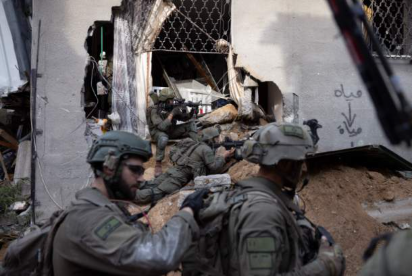 Tentara Israel mengambil bagian dalam operasi darat di lingkungan Shujaiya Kota Gaza, Jumat, 8 Desember 2023.