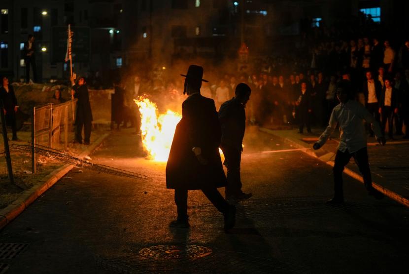 Pria Yahudi ultra-Ortodoks membakar sampah saat protes menentang perekrutan tentara di Yerusalem pada Ahad, 30 Juni 2024.