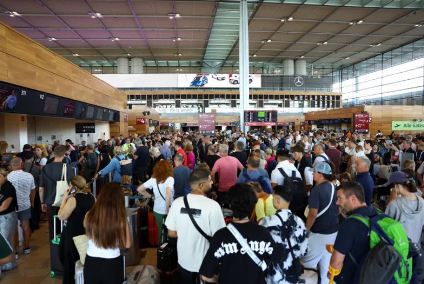 Penumpang menumpuk setelah pembatalan penerbangan akibat gangguan sistem IT di bandara Berlin Brandenburg di Berlin, Jumat (19/7/2024).