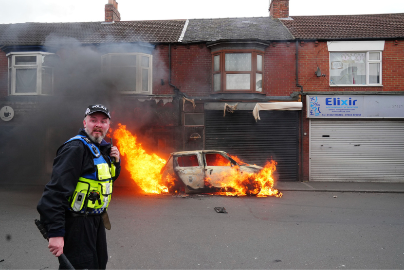 Sebuah mobil terbakar di Parliament Road, di Middlesbrough, Inggris, menyusul protes anti-imigrasi pada Ahad, 4 Agustus 2024.