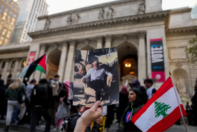 Seseorang memegang gambar pemimpin Hamas Yahya Sinwar yang terbunuh selama protes di Perpustakaan Umum New York di Kota New York pada 18 Oktober 2024.