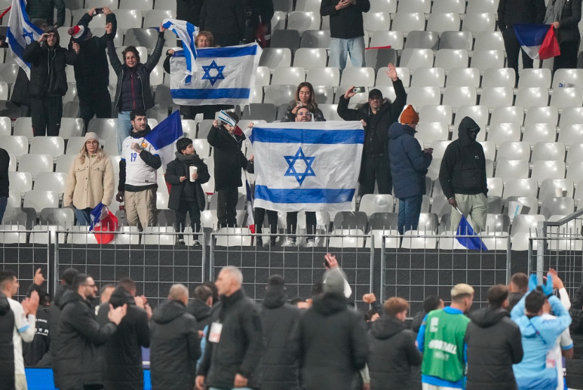 Pendukung sepak bola Israel membentangkan bendera dalam pertandingan Nations League Prancis melawan Israel di stadion Stade de France, Kamis, 14 November 2024 di Saint-Denis.