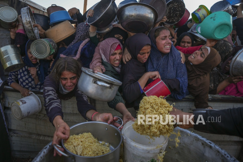 Gadis dan perempuan Palestina berjuang untuk mendapatkan makanan di pusat distribusi di Khan Younis, Jalur Gaza Jumat, 6 Desember 2024.  Agresi Israel telah menyebabkan kelaparan parah di Jalur Gaza.