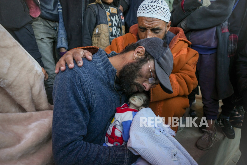 Yahya al-Batran menggendong jenazah Juma (30 hari), yang meninggal karena kedinginan, di Gaza tengah, Ahad, 29 Desember 2024.